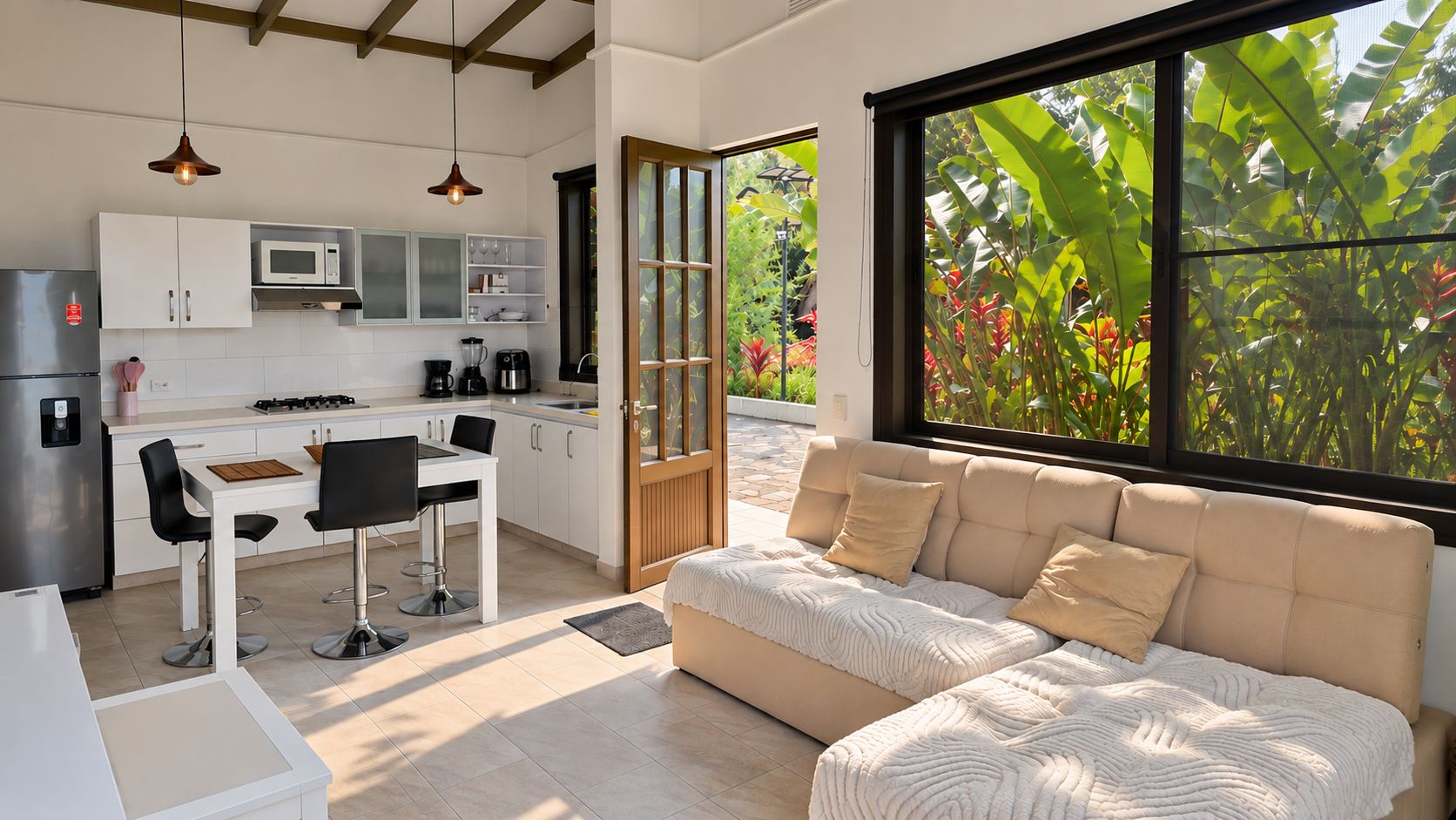 A modern kitchen with a dining area and a large window with a view of greenery.