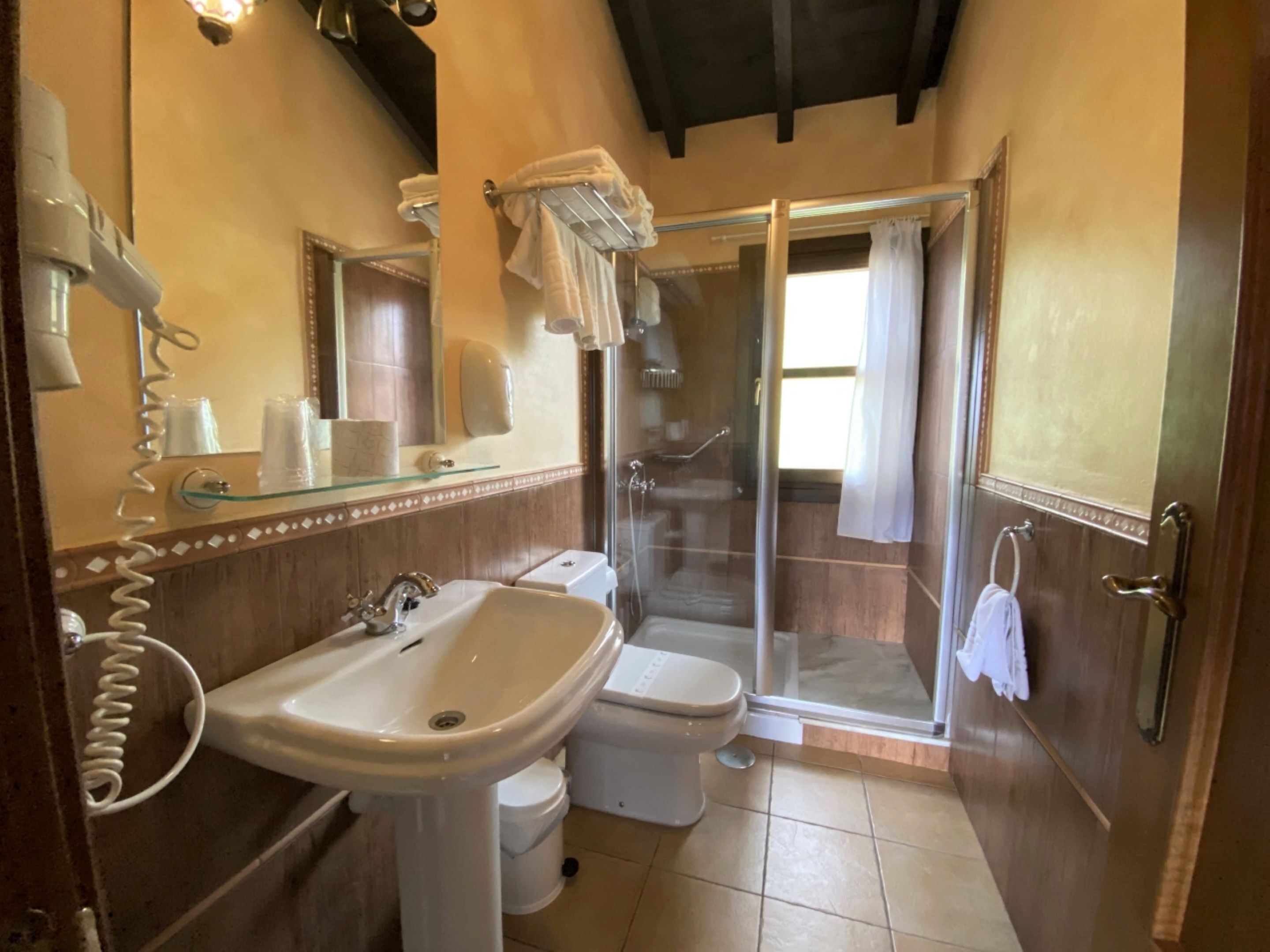 A bathroom with a sink, toilet, and glass shower enclosure.
