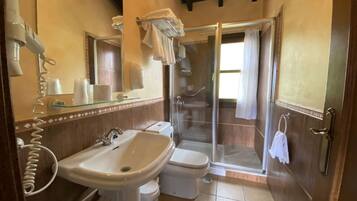 A bathroom with a sink, toilet, and glass shower enclosure.
