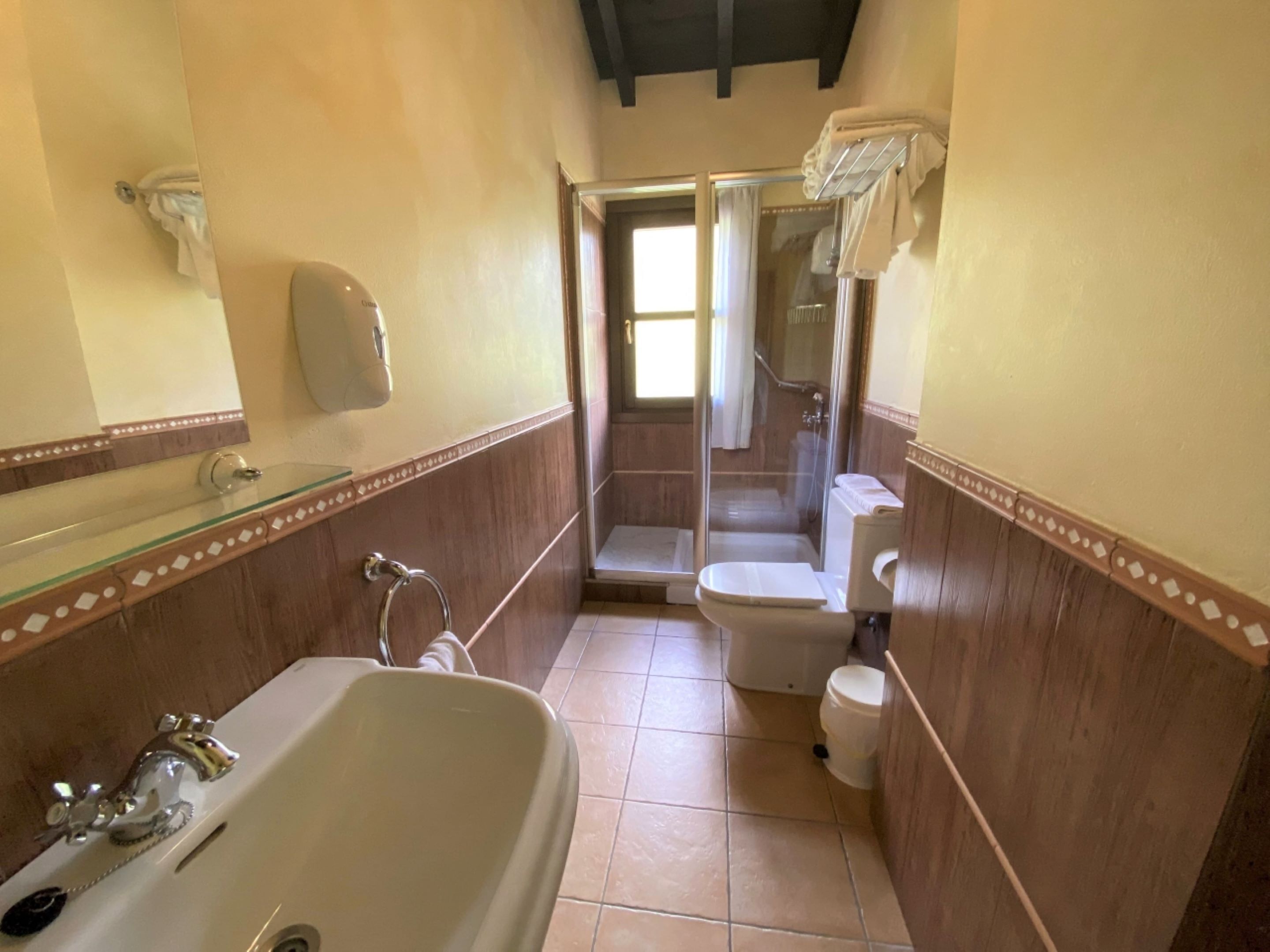 A bathroom with a bathtub, toilet, and shower area.