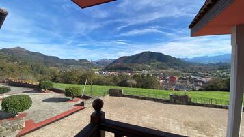 A balcony with a view of a town and mountains.