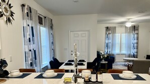 Une cuisine moderne équipée d’un évier, d’une horloge décorative et d’un coin repas avec une table et des chaises.