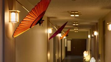 A hallway with hanging decorative elements and wall-mounted lights.
