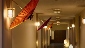 A hallway with hanging decorative elements and wall-mounted lights. - Misasa Royal Hotel (Misasa)