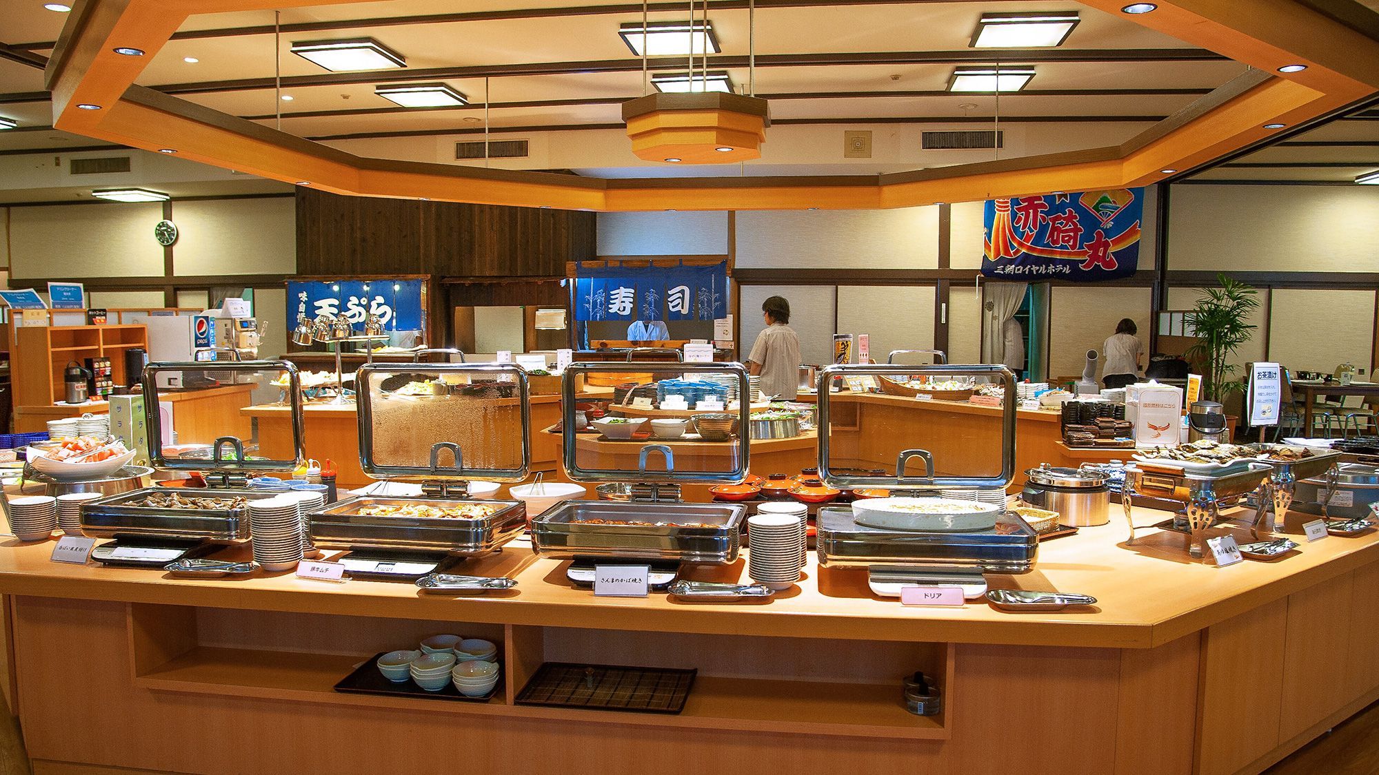 A buffet counter with various food items and a clock on the wall.