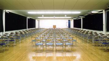 A large hall with rows of chairs facing a podium at the front.