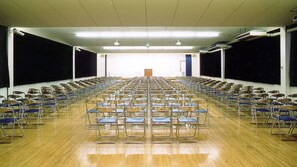 A large hall with rows of chairs facing a podium at the front. - Misasa Royal Hotel (Misasa)