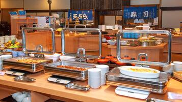 A buffet setup with various food items and utensils.