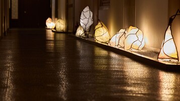 Un pasillo con una hilera de faroles de papel iluminados a lo largo de la pared.