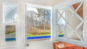 A white door with a view of a forest and a blue pathway. - Captain Green s Cabin (Copalis Beach)