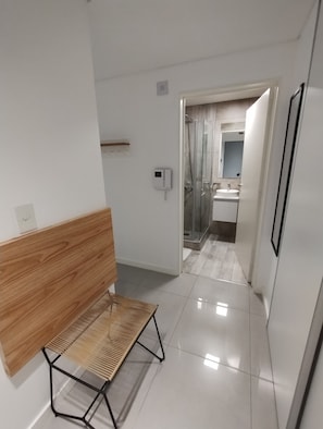 A modern bathroom with a glass shower enclosure, a white sink, and a mirror.