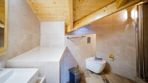Ein modernes Badezimmer mit Badewanne, Toilette und Dusche.