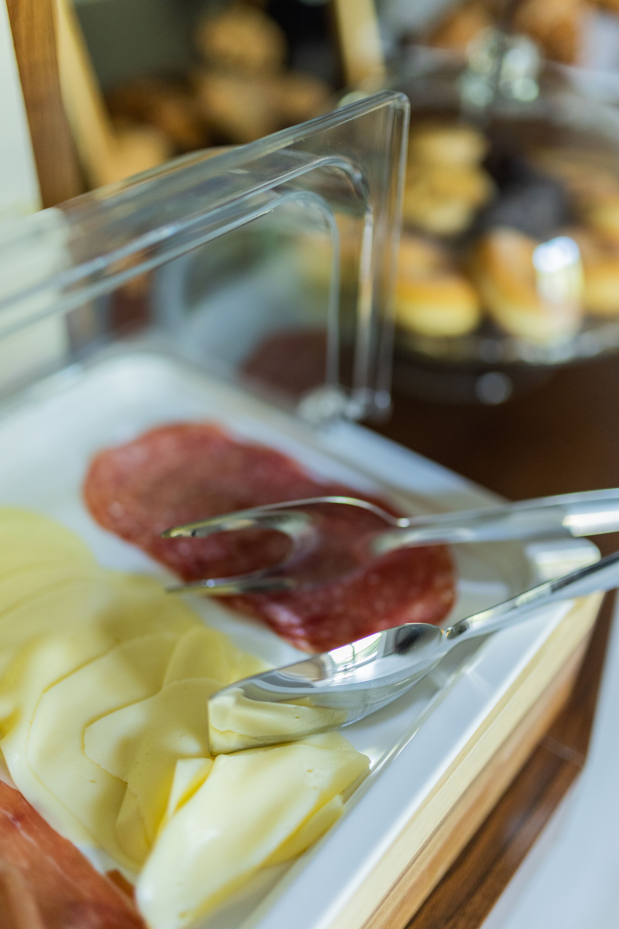 Un buffet proposant une variété de plats, notamment des viandes et des fromages en tranches.
