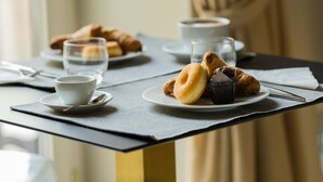Een tafel met gebak, een kopje en een glas water.