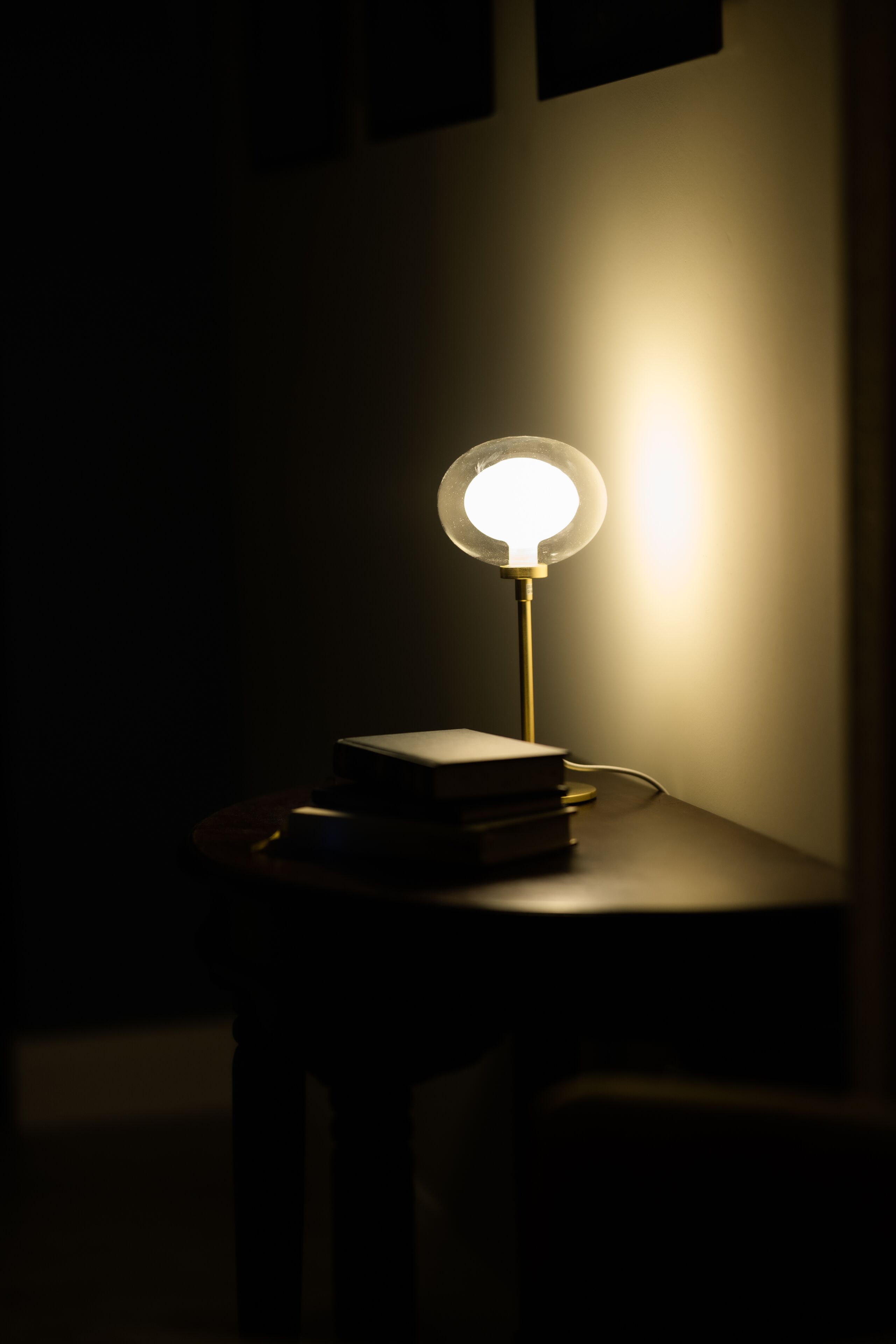 Una mesa con una lámpara y libros.