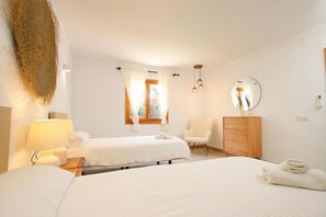 A hotel room with two beds, a chair, a bedside table with lamps, a mirror, and a window with curtains. - H2927 Finca Alegre near Pollenca for 4 persons with pool (Pollenca)