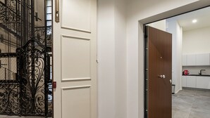 A hallway with a white door, a wooden door, and a metal gate. - Zecca Contemporary Loft by Wonderful Italy (Genoa)