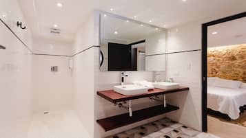 Een moderne badkamer met een grote spiegel, twee wastafels en een douche.