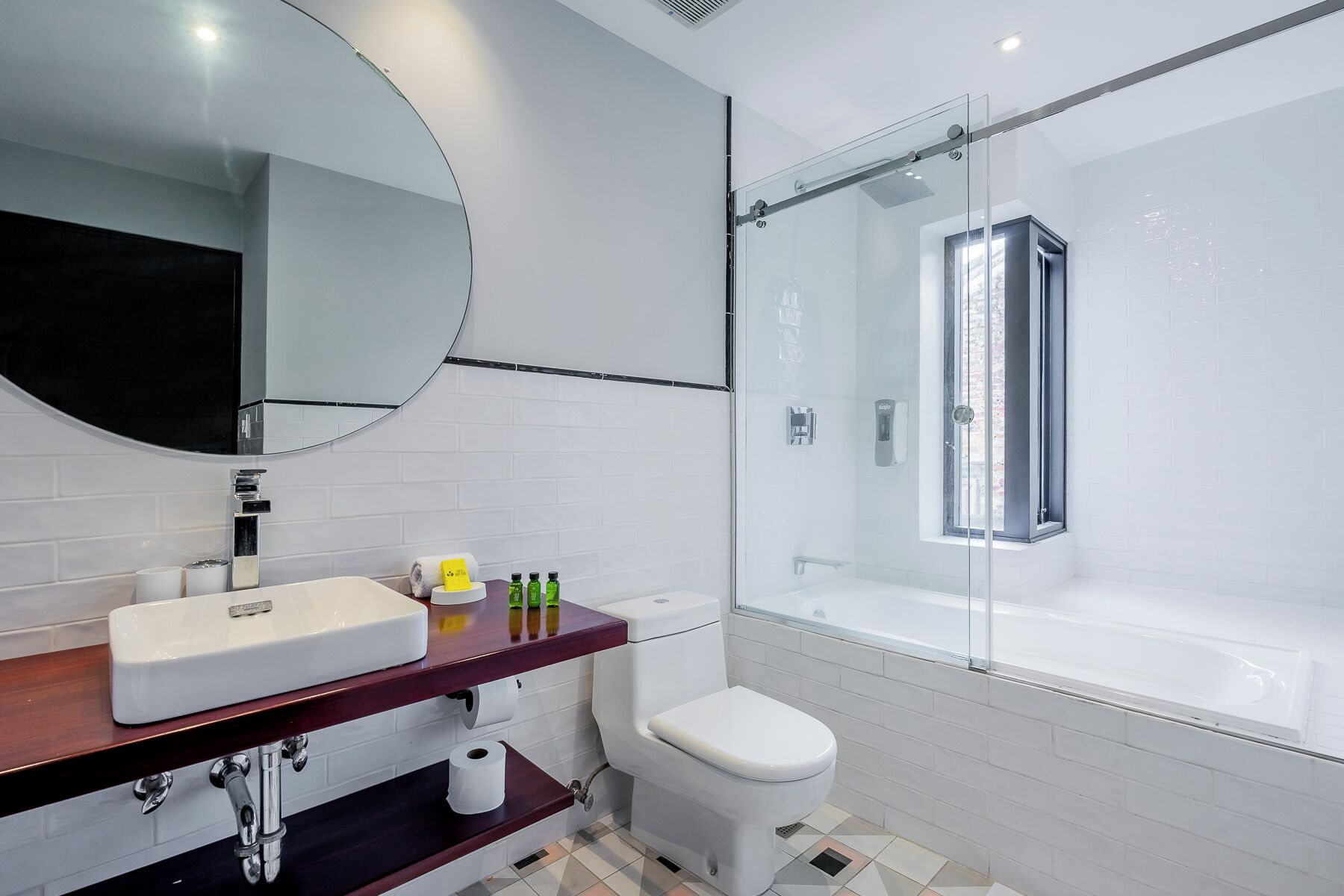 A modern bathroom with a white sink, mirror, toilet, and glass-enclosed shower.