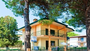 Un immeuble de deux étages doté d’un balcon, d’une enseigne indiquant le prix de la location et d’un espace de stationnement clôturé.