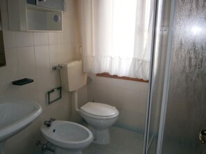 Un baño pequeño con inodoro, bidé y lavamanos.