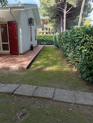 Una propiedad residencial con entrada pavimentada, césped cuidado y seto.