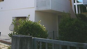 Een modern gebouw met balkon, schotelantenne en heldere lucht.