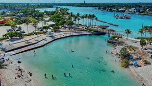 A coastal area with a beach, clear turquoise water, and a pier. - Lucky Landing's (Jupiter)