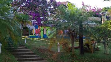 A garden with a stone staircase leading to a colorful building.