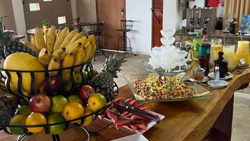 Ein reichhaltiges Buffet mit verschiedenen Früchten, Gemüse und einer Schale geschnittene Karotten.