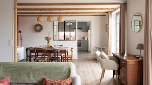 Un vaste espace de vie comprenant une table à manger, un canapé et un bureau.