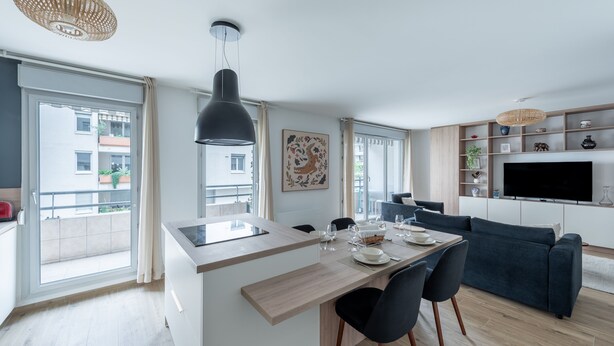 Een modern appartement met een kookeiland, een eethoek en een woongedeelte.