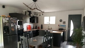 Una cocina moderna con una isla central, electrodomésticos de acero inoxidable y una lámpara colgante original.