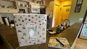 A kitchen with a refrigerator, microwave, and various kitchen items on shelves. - Secluded and Secure, Pet-friendly Desert Getaway. Your vacation awaits! (Lake Havasu City)