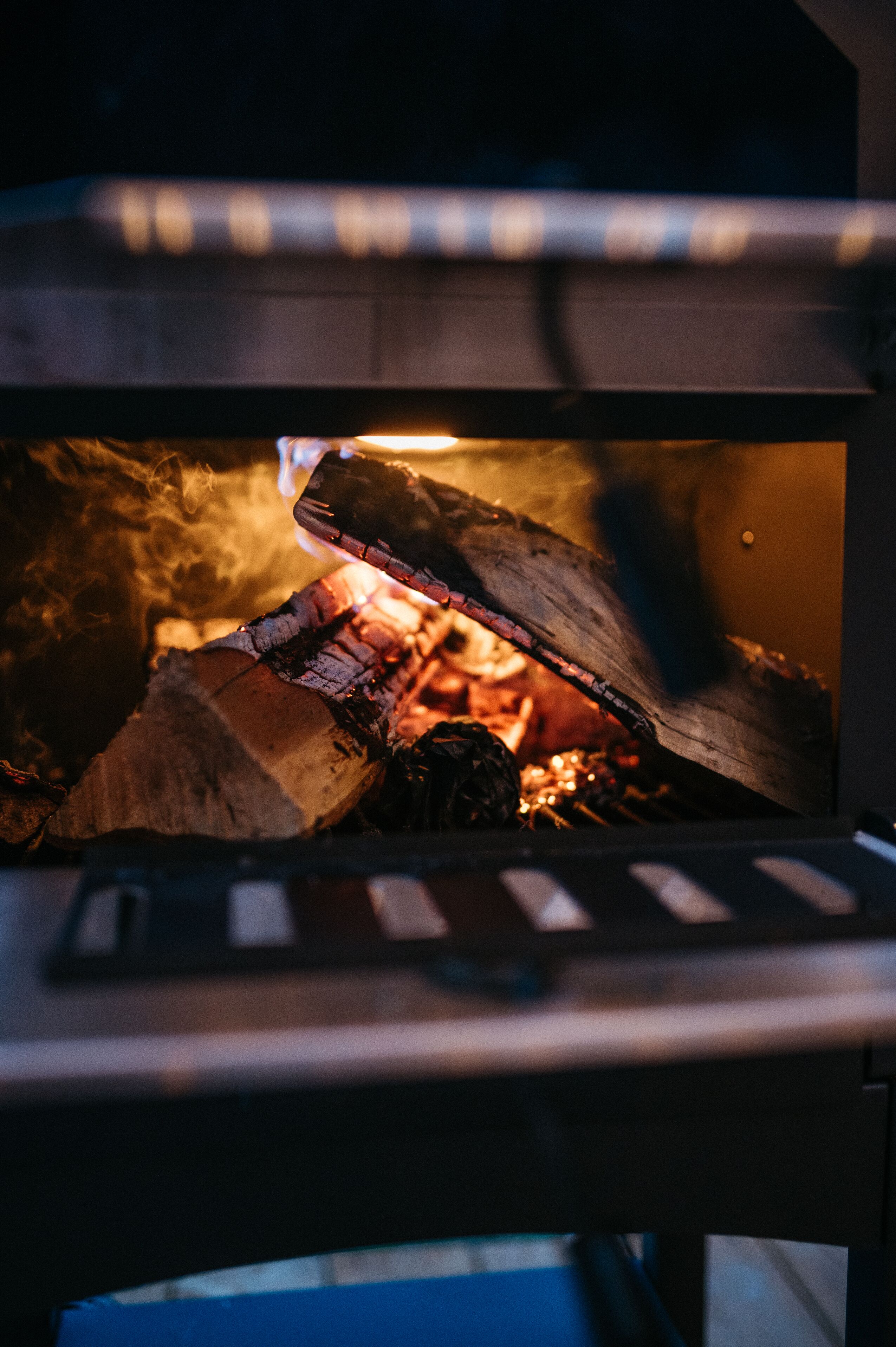 A close-up of a wood fire burning inside a fireplace.