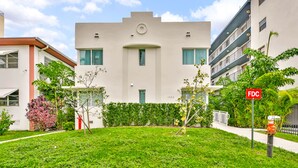A modern building with a flat roof, a central circular window, and a small balcony. - West Deco Boutique Apartments (Miami Beach)