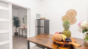 A kitchen with a wooden table, a refrigerator, and a potted plant. - West Deco Boutique Apartments (Miami Beach)