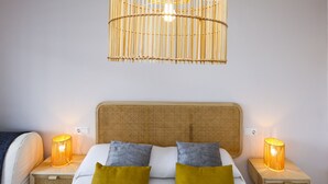 A bedroom with a bed, two bedside tables, a hanging light fixture, and a wall socket. - SOLIMAR Apartment - Only Families (Cambrils)