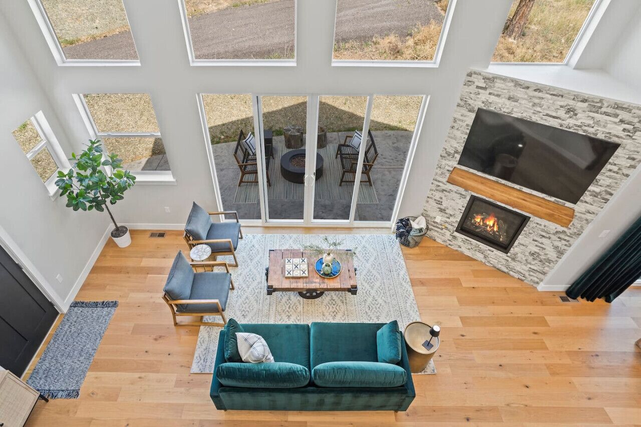 A spacious living room with a large window, a fireplace, and a cozy seating area.