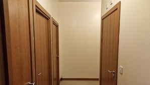 A hallway with wooden doors and a beige carpet. - Impeccable 1-bed Apartment in Purfleet (Purfleet)