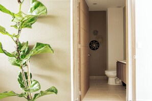 Een badkamer met toilet, houten kastje en decoratieve wanddecoratie.