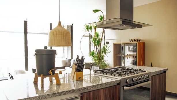 Een moderne keuken met een gasfornuis, houten kastjes en een inbouwoven.