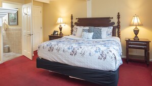 A bedroom with a large bed, two bedside tables with lamps, a door, and a small window. - Small Private suite with Electric Fireplace and Pet Friendly (Blowing Rock)