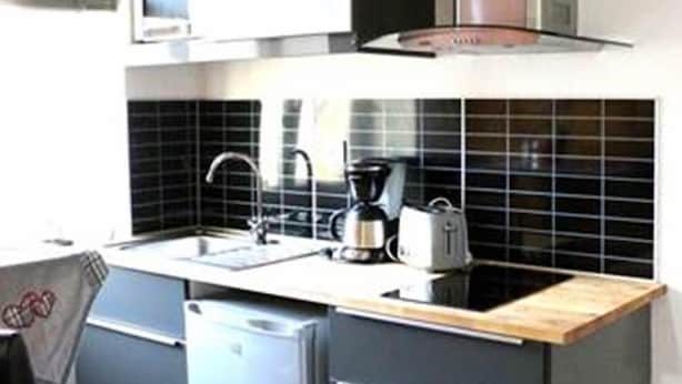 Een kleine keuken met een spoelbak, koffiezetapparaat en broodrooster.
