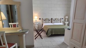 Une chambre à coucher avec un lit, des lampes de chevet, un miroir, un bureau et une chaise.