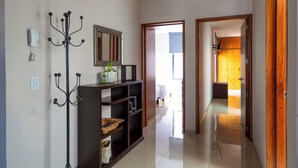 A hallway with a coat rack, a mirror, and a console table with shelves. - Casa un Solo Piso, 2 min Hospital Real San Lucas (Tepatitlán de Morelos)