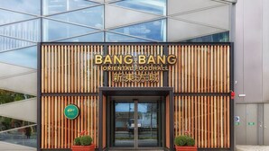 The exterior of a building with a sign reading "BANG BANG ORIENTAL FOODHALL" and Chinese characters. There are two potted plants on either side of the entrance. - Modern 2 bedroom and 2 Bath Apartment in London - Pass the Keys (Edgware)