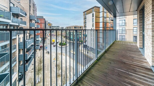 A balcony with a view of a cityscape, featuring modern buildings and a roundabout. - Modern 2 bedroom and 2 Bath Apartment in London - Pass the Keys (Edgware)