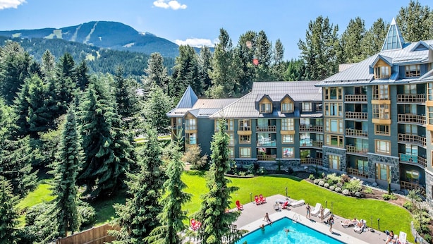 A resort with a pool, multiple guest rooms, and a mountainous backdrop. - Ace Cascade (Whistler)
