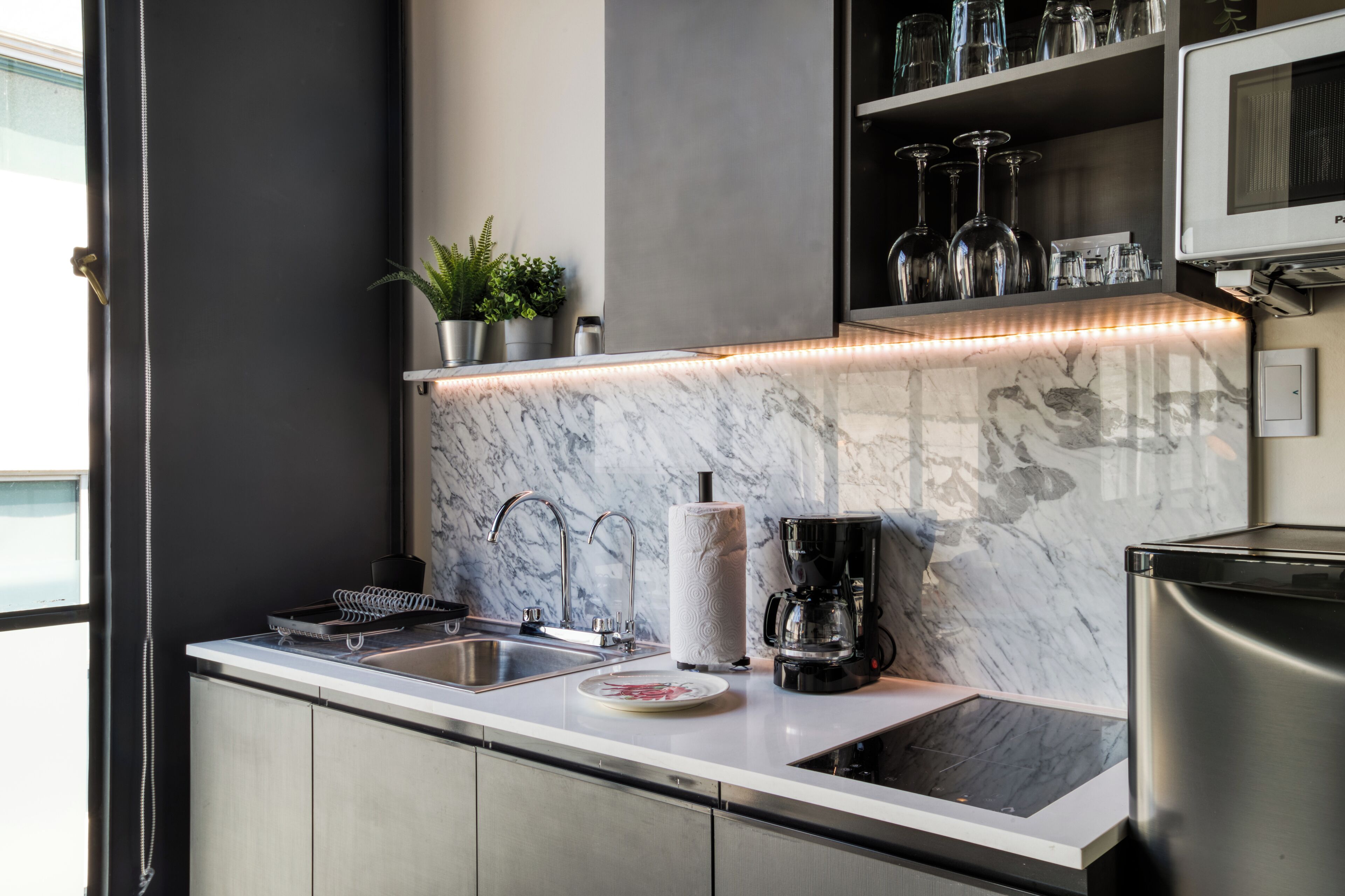 A modern kitchen with a marble countertop, stainless steel appliances, and a built-in microwave.